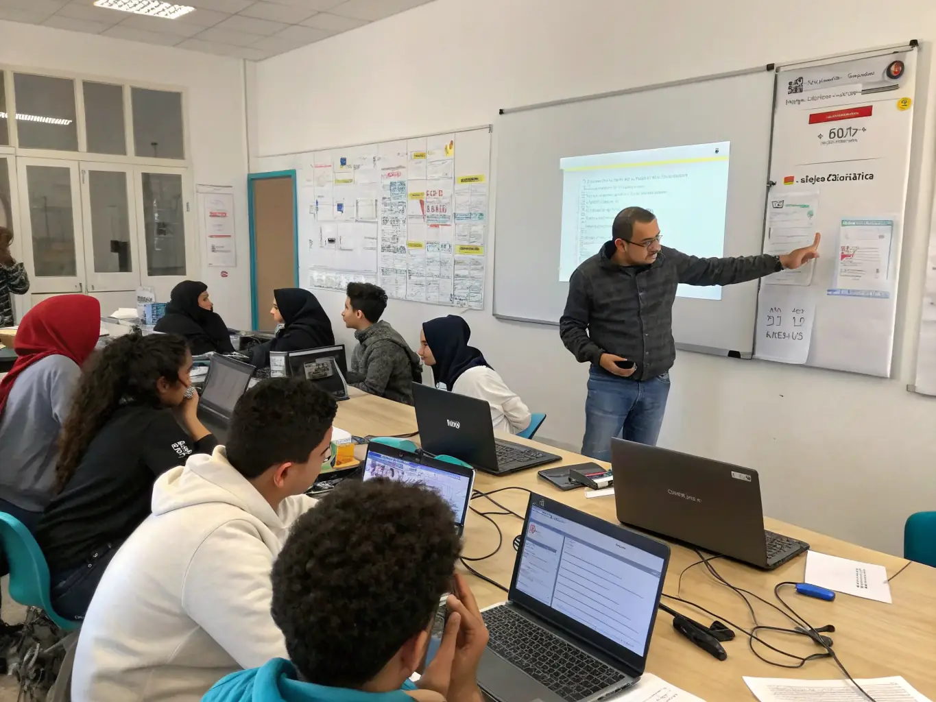 A well-equipped ICT lab at Chinhoyi High School, with students working on computers and a teacher providing guidance.